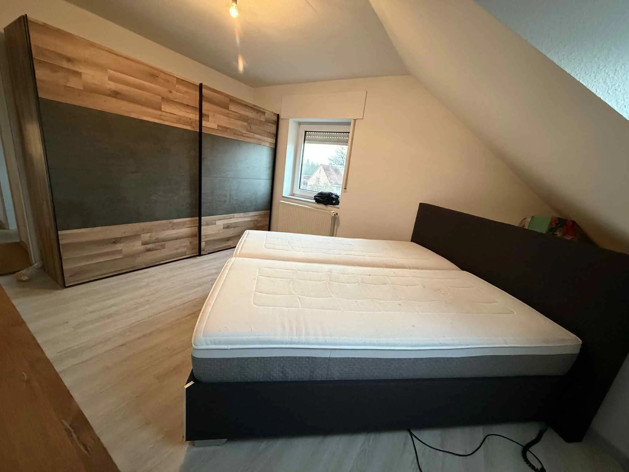 Schlafzimmer mit Holzvertäfelung und Bett, ideal für Bodenbeschichtung oder Bodenreinigung