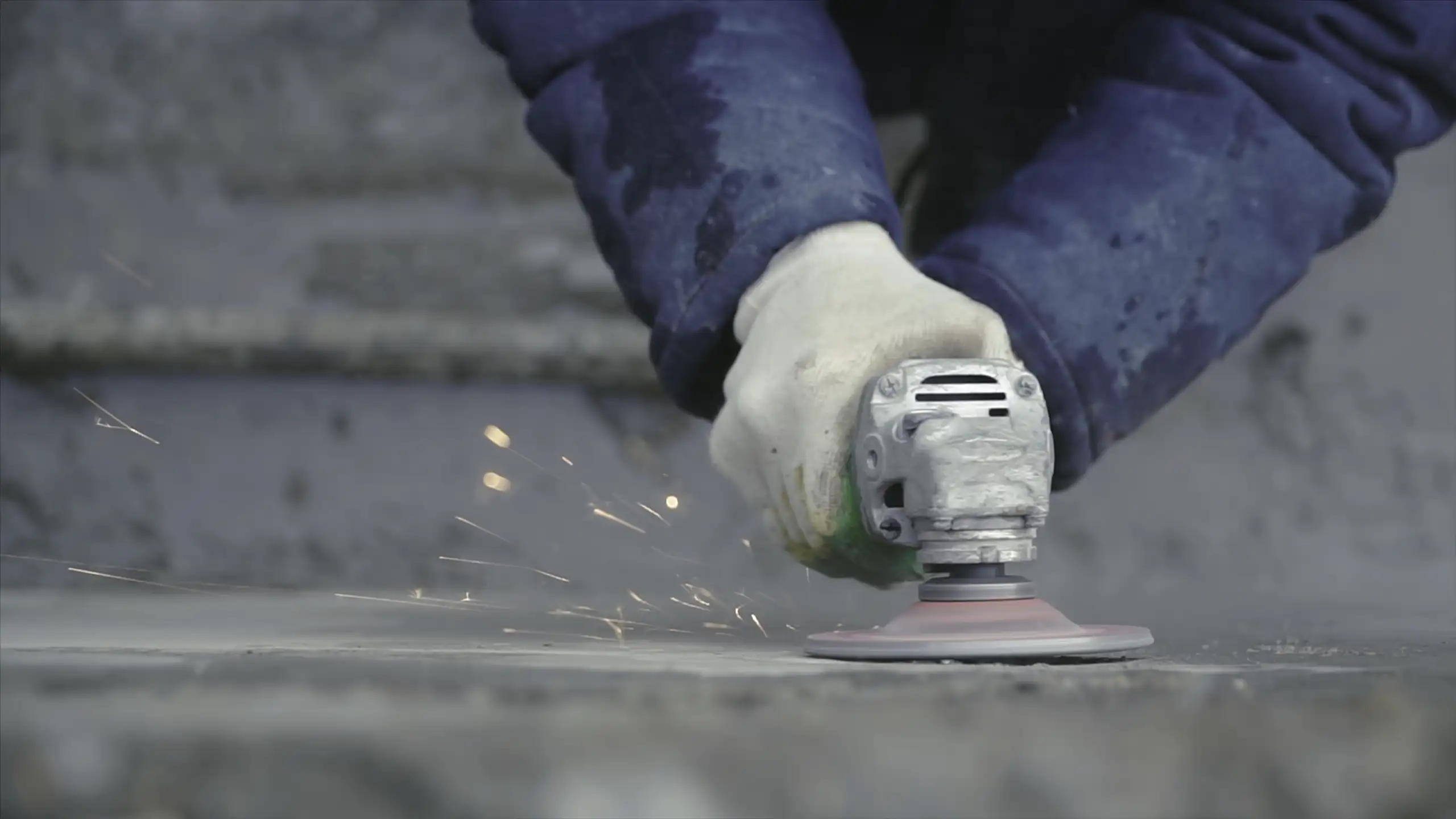 Beton schleifen mit einer Schleifmaschine, Funken sprühen von der bearbeiteten Fläche