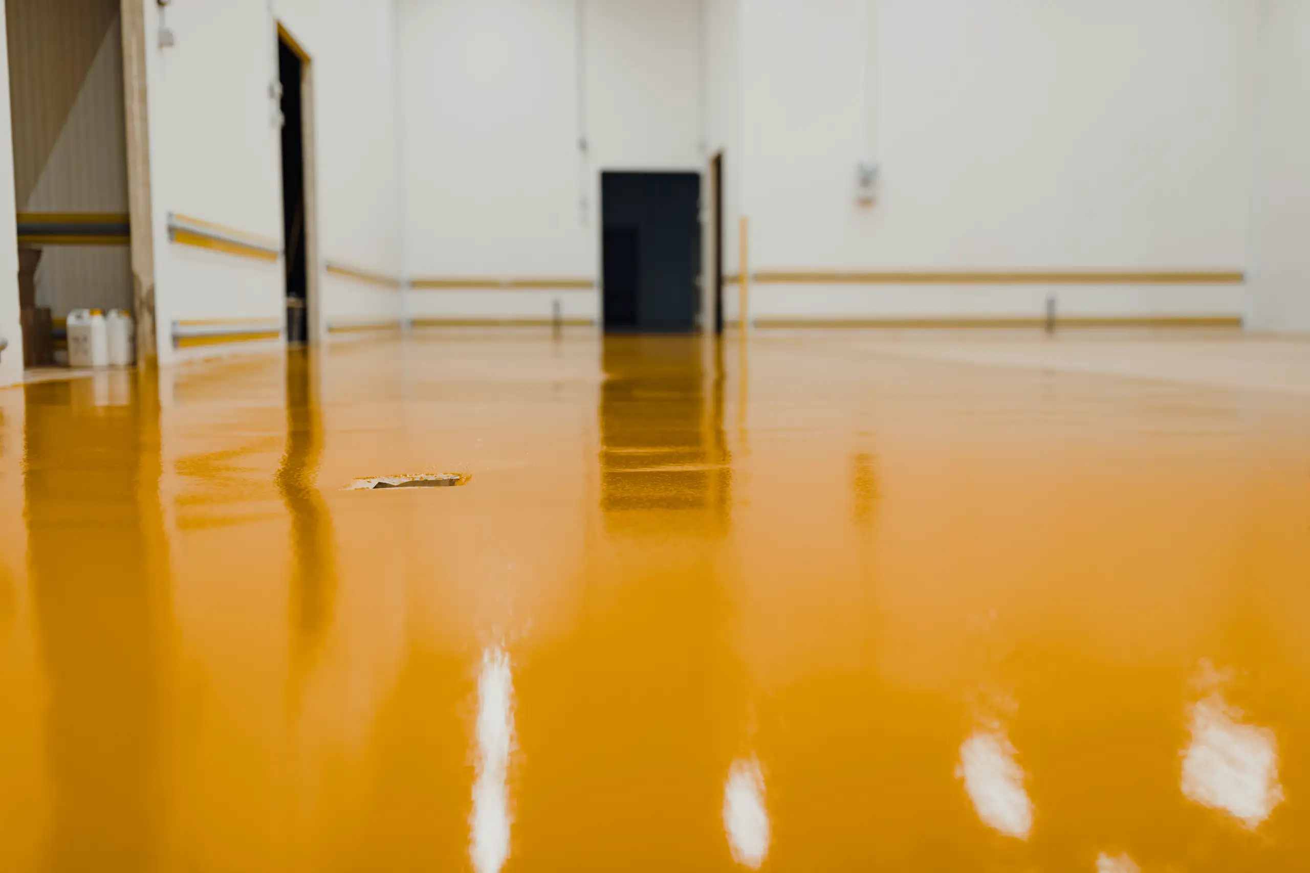 Glatter, orangefarbener Epoxidharzboden in einem geräumigen Industriebereich